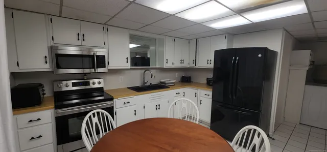 a kitchen with a refrigerator and a stove top oven