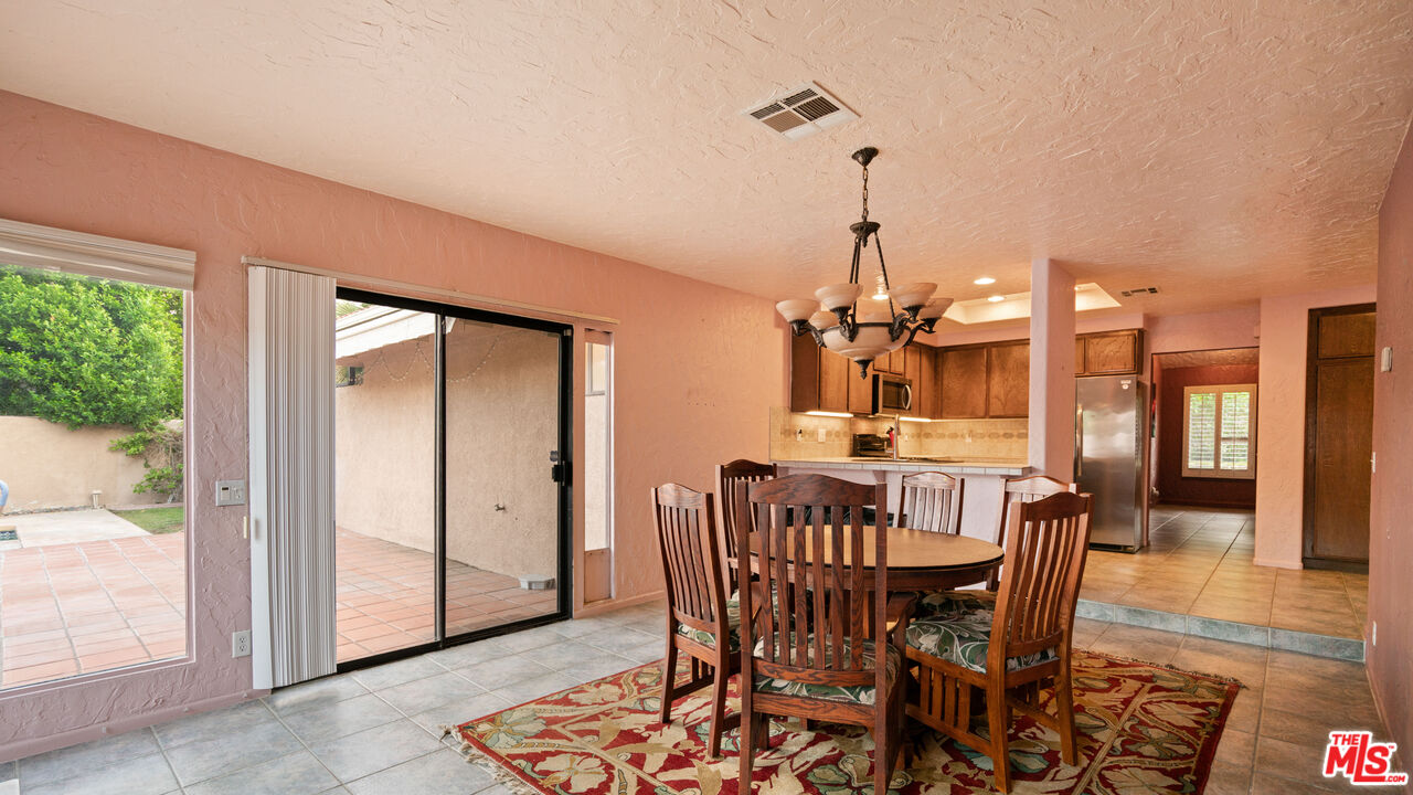 1592 South Compadre Road Palm Springs, CA 92264 - Photo 15 of 53 a view of a dining room with furniture window and wooden floor