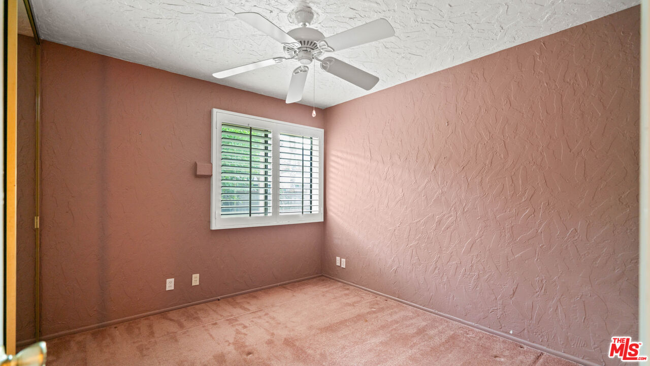 1592 South Compadre Road Palm Springs, CA 92264 - Photo 18 of 53 an empty room with a chandelier fan and windows