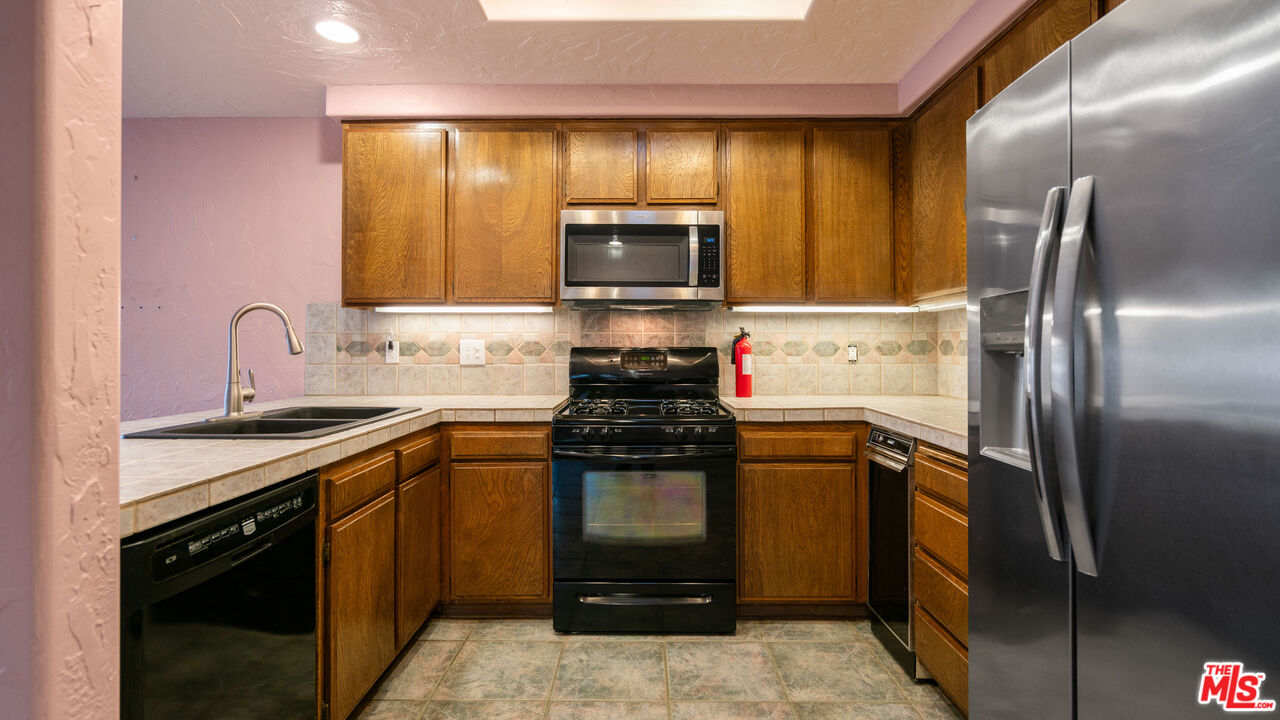 1592 South Compadre Road Palm Springs, CA 92264 - Photo 21 of 53 a kitchen with a sink stove and refrigerator