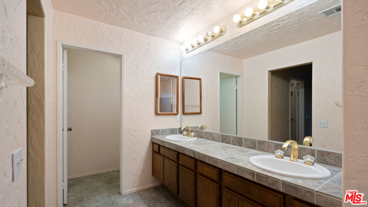 1592 South Compadre Road Palm Springs, CA 92264 - Photo 23 of 53 a bathroom with a double vanity sink and a mirror