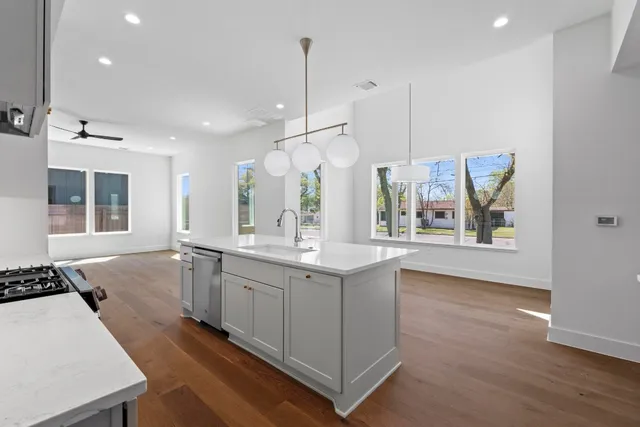 a kitchen with granite countertop white cabinets and white appliances