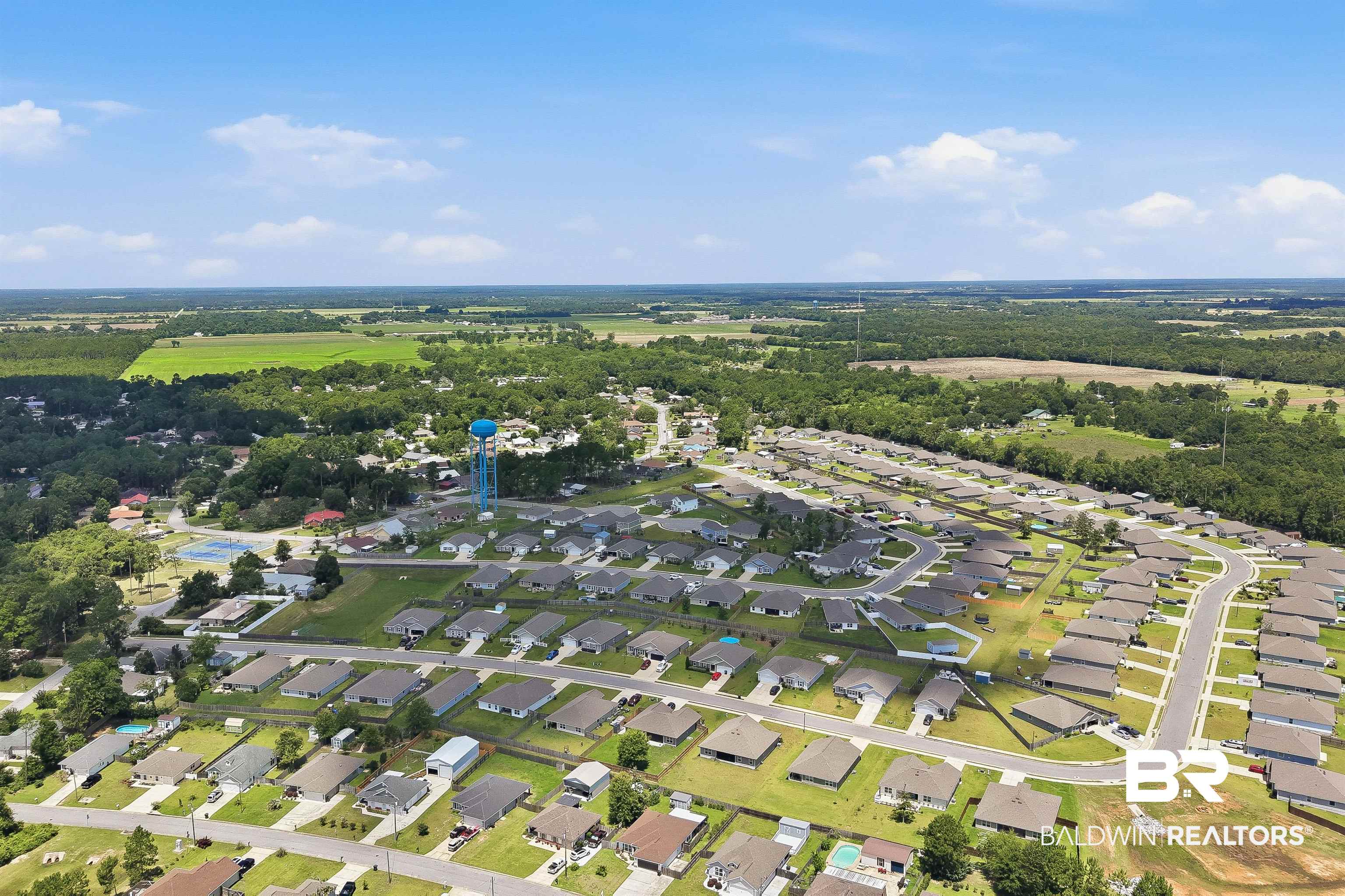 3213 Camino Real Loop Lillian, AL 36549 - Photo 15 of 61 Expansive aerial perspective showcasing a residential development with numerous single-story homes, curved streets, and individual green spaces