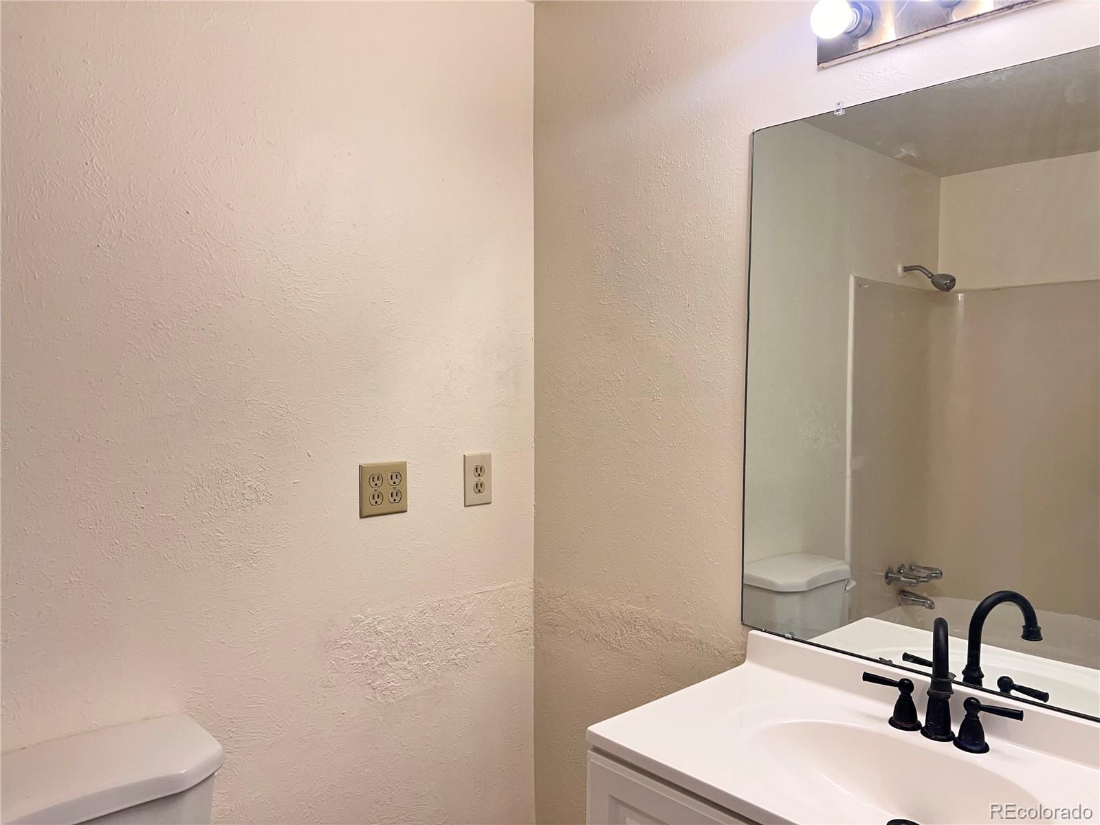 875 South Quebec Street, Unit 29 Denver, CO 80247 - Photo 11 of 13 a bathroom with a sink and a mirror