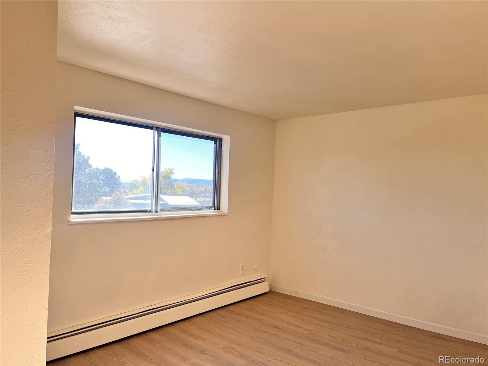 875 South Quebec Street, Unit 29 Denver, CO 80247 - Photo 9 of 13 an empty room with wooden floor and windows