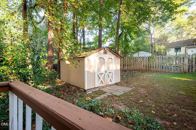 a view of a yard with wooden fence and trees