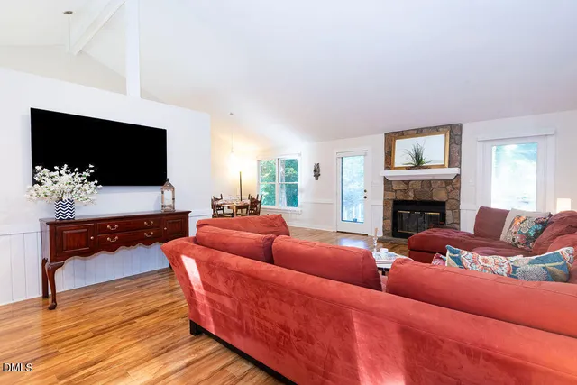 a living room with furniture a flat screen tv and a fireplace