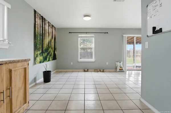 a view of an empty room with window and a kitchen