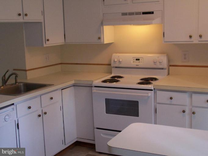 11930 Fieldthorn Court Reston, VA 20194 - Photo 2 of 12 a kitchen with white cabinets and white appliances