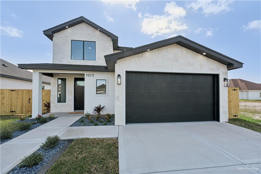 1013 Azalea Street Mission, TX 78573 - Photo 1 of 35 Contemporary home with stone siding, driveway, and a garage