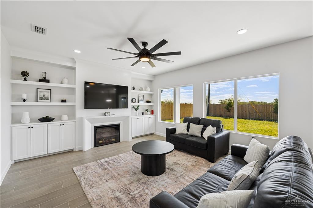 1013 Azalea Street Mission, TX 78573 - Photo 17 of 35 Living area with wood finish floors, a glass covered fireplace, ceiling fan, and recessed lighting