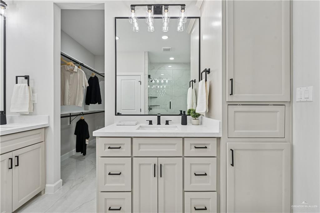 1013 Azalea Street Mission, TX 78573 - Photo 21 of 35 Full bath featuring a marble finish shower, light marble finish flooring, two vanities, recessed lighting, and a spacious closet
