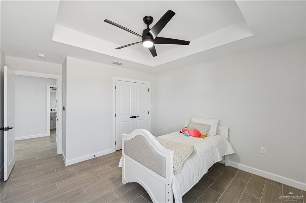 1013 Azalea Street Mission, TX 78573 - Photo 29 of 35 Bedroom featuring a raised ceiling, wood finish floors, and ceiling fan