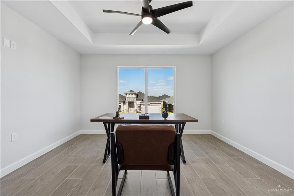 1013 Azalea Street Mission, TX 78573 - Photo 34 of 35 Dining space featuring a desk, a raised ceiling, wood tiled floors, and a ceiling fan