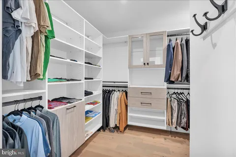 a view of walk in closet with clothes and shoes