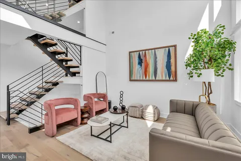 a living room with furniture plant and a window