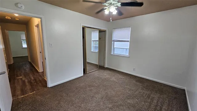 an empty room with closet and fan