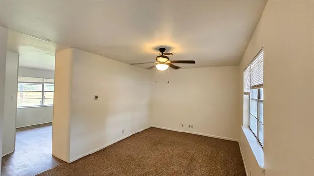 a view of a room with a large window and wooden floor