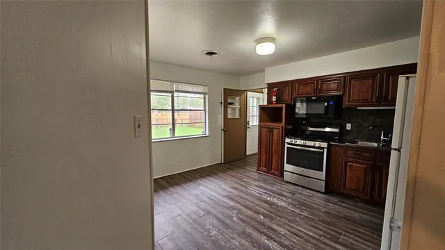 a kitchen with stainless steel appliances a refrigerator and a stove top oven