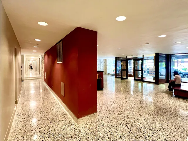 a view of a hallway with dining area and chandelier