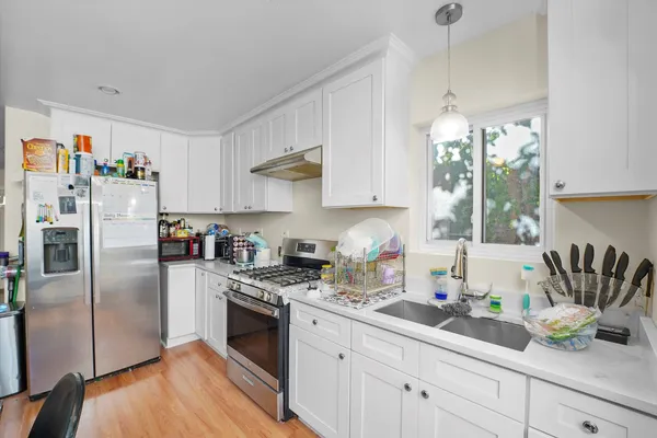 a kitchen with granite countertop a sink a counter space appliances and cabinets