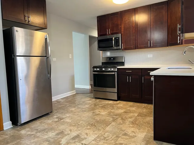 a kitchen with stainless steel appliances granite countertop a refrigerator a stove a sink and a refrigerator