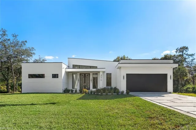 a front view of a house with a garden and yard
