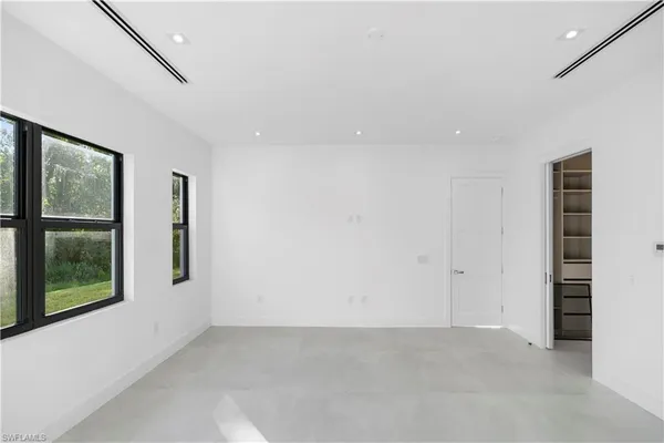 an empty room with windows and closet