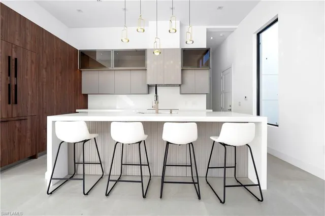 a kitchen with a table chairs refrigerator and cabinets