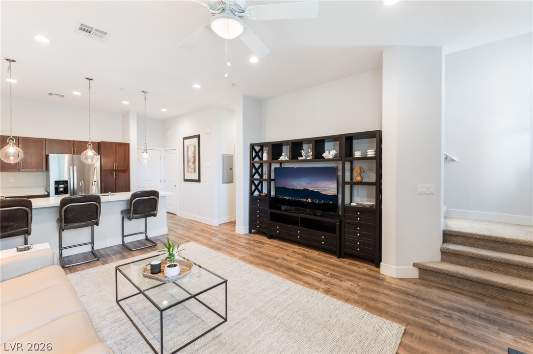 6432 Spring Jog Street Las Vegas, NV 89166 - Photo 7 of 61 An open concept living area blends effortlessly into a modern kitchen, featuring sleek cabinetry and recessed lighting.