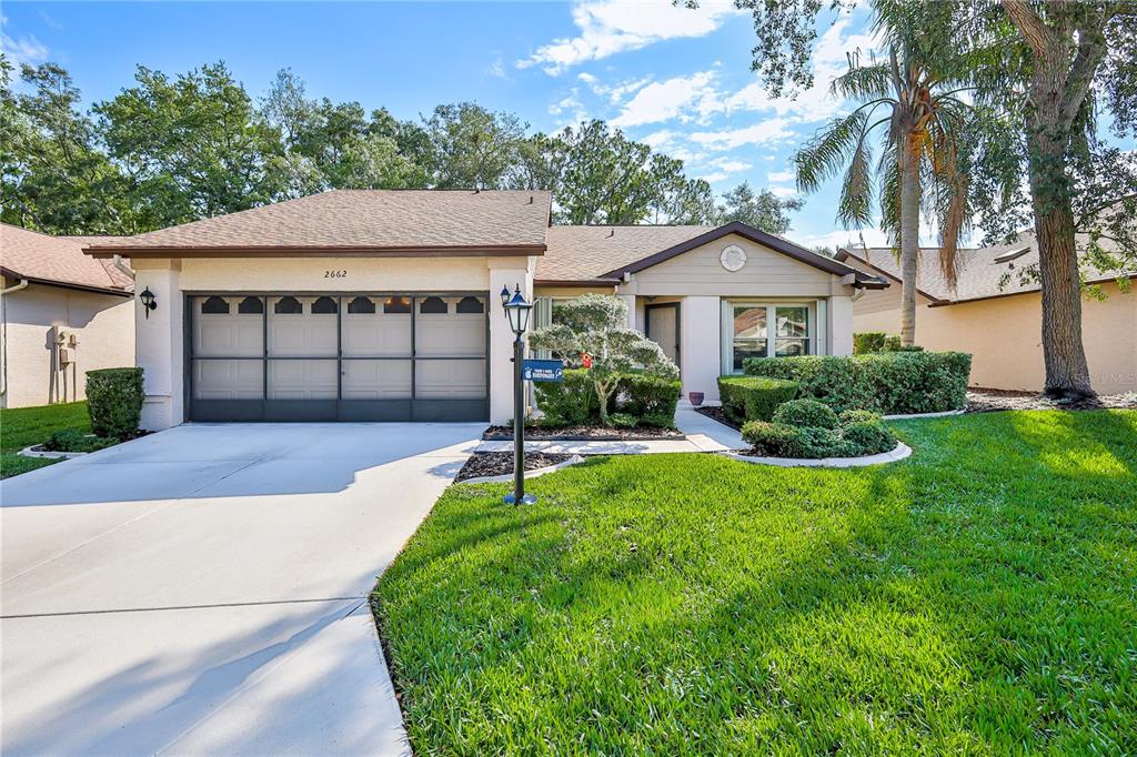 2662 Appleleaf Court Spring Hill, FL 34606 - Photo 1 of 47 a front view of a house with a garden and plants