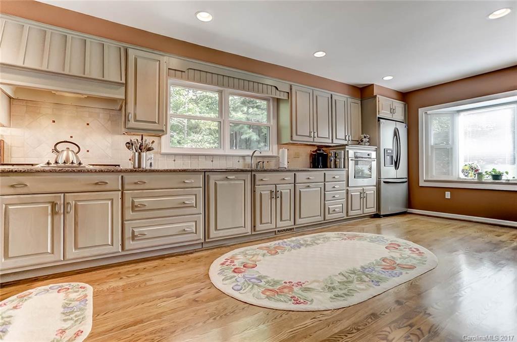 31001 Executive Point Tega Cay, SC 29708 - Photo 8 of 24 a large kitchen with cabinets and wooden floor