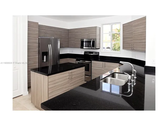 a kitchen with a refrigerator a stove a sink and a window