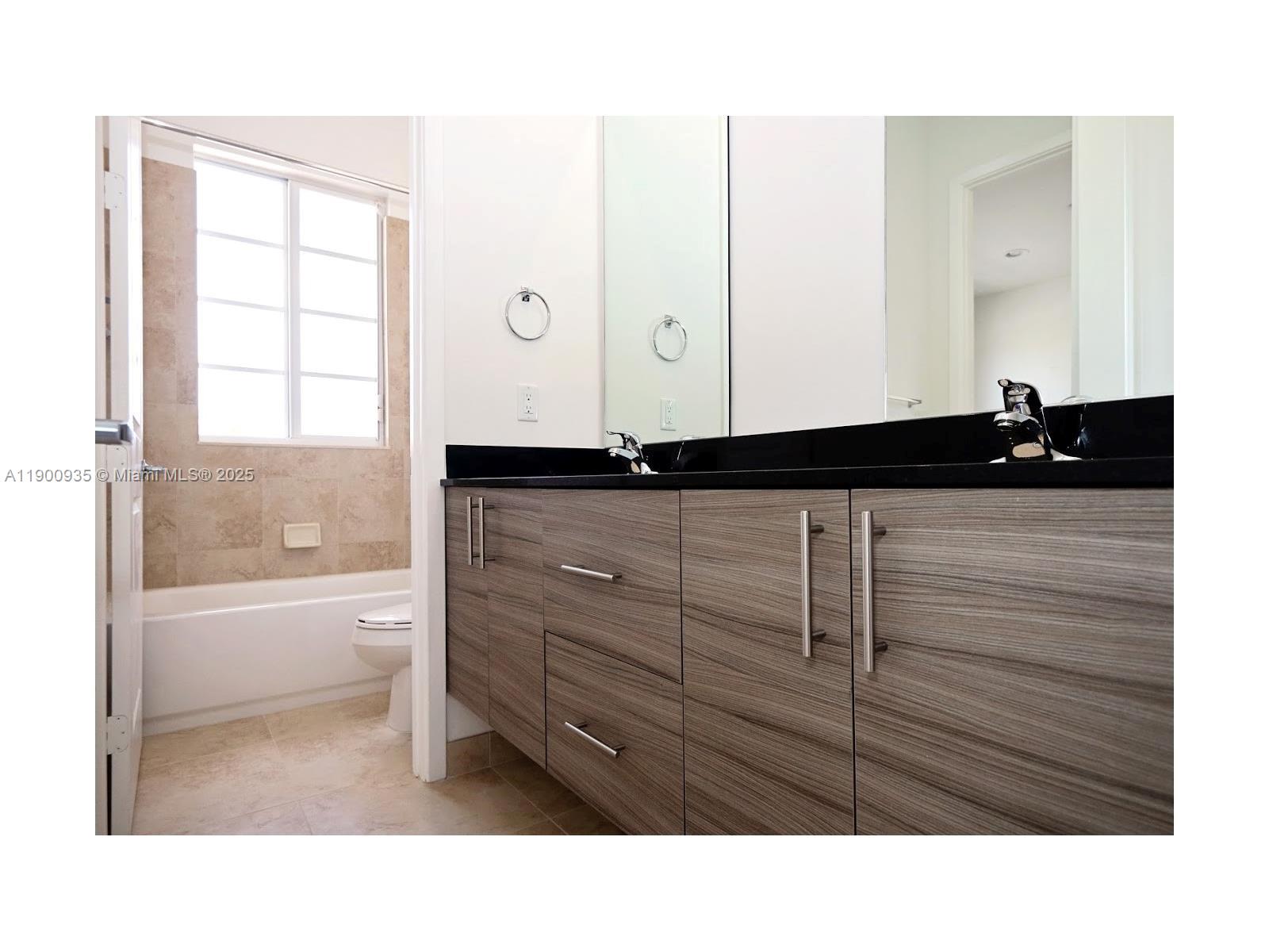 2714 Southwest 81st Terrace, Unit 2718 Miramar, FL 33025 - Photo 5 of 12 a bathroom with a sink a mirror and a bathtub