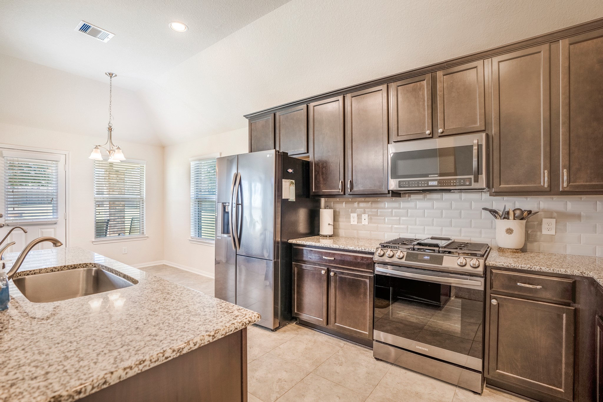 1730 Wandering Hills Road Conroe, TX 77304 - Photo 25 of 45 a kitchen with stainless steel appliances granite countertop a sink stove and refrigerator