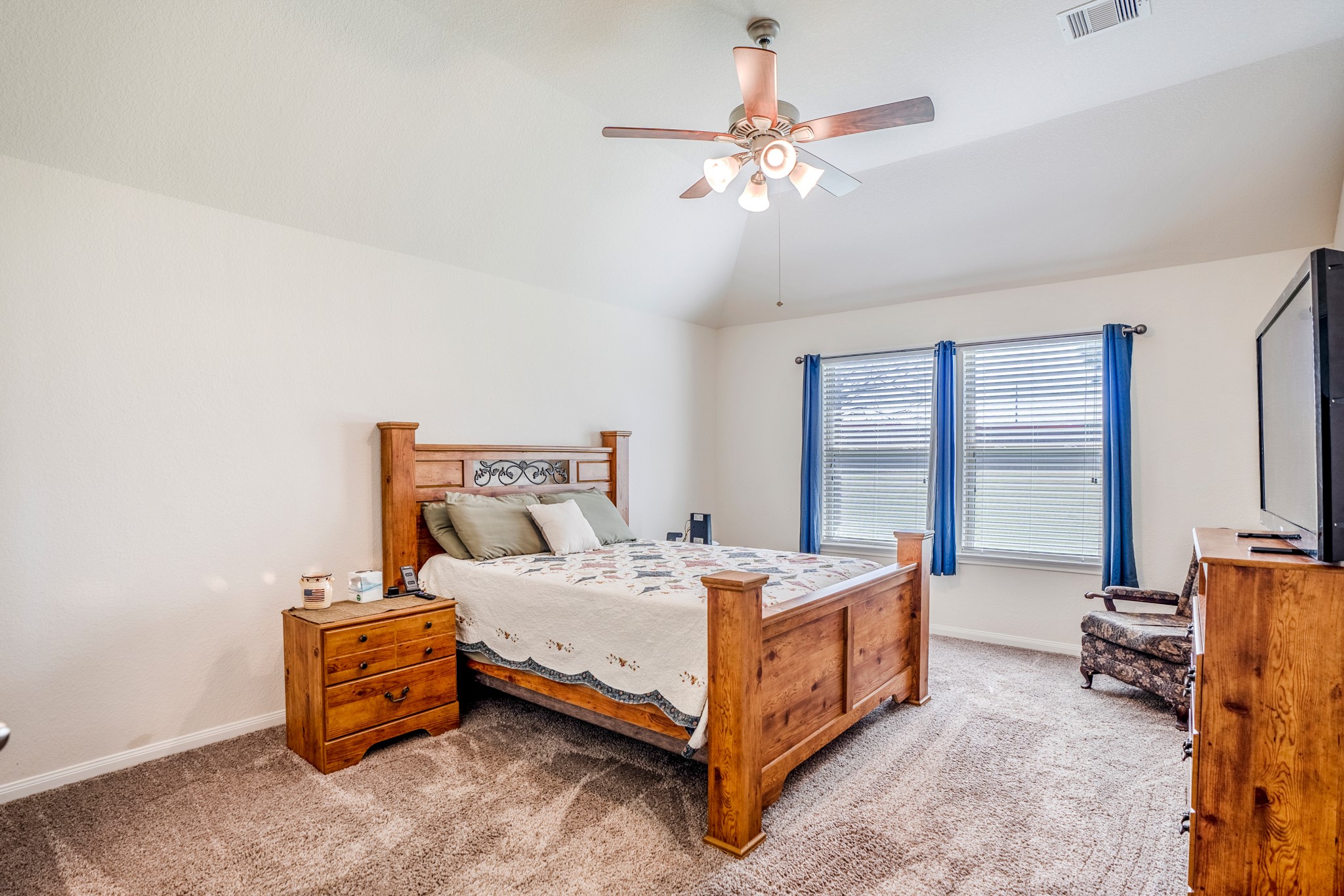 1730 Wandering Hills Road Conroe, TX 77304 - Photo 26 of 45 a bedroom with a bed and a chandelier