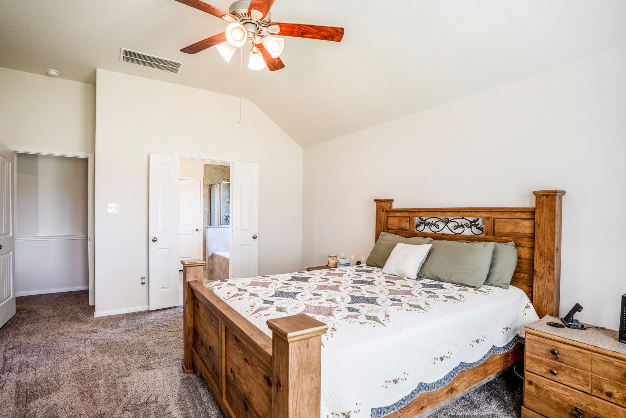 1730 Wandering Hills Road Conroe, TX 77304 - Photo 27 of 45 a bedroom with a bed and a chandelier