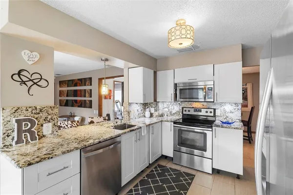 a kitchen with stainless steel appliances granite countertop a sink and a stove