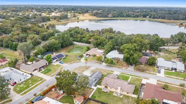 an aerial view of residential houses with outdoor space and lake view