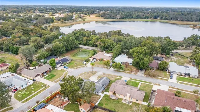 an aerial view of residential houses with outdoor space and lake view