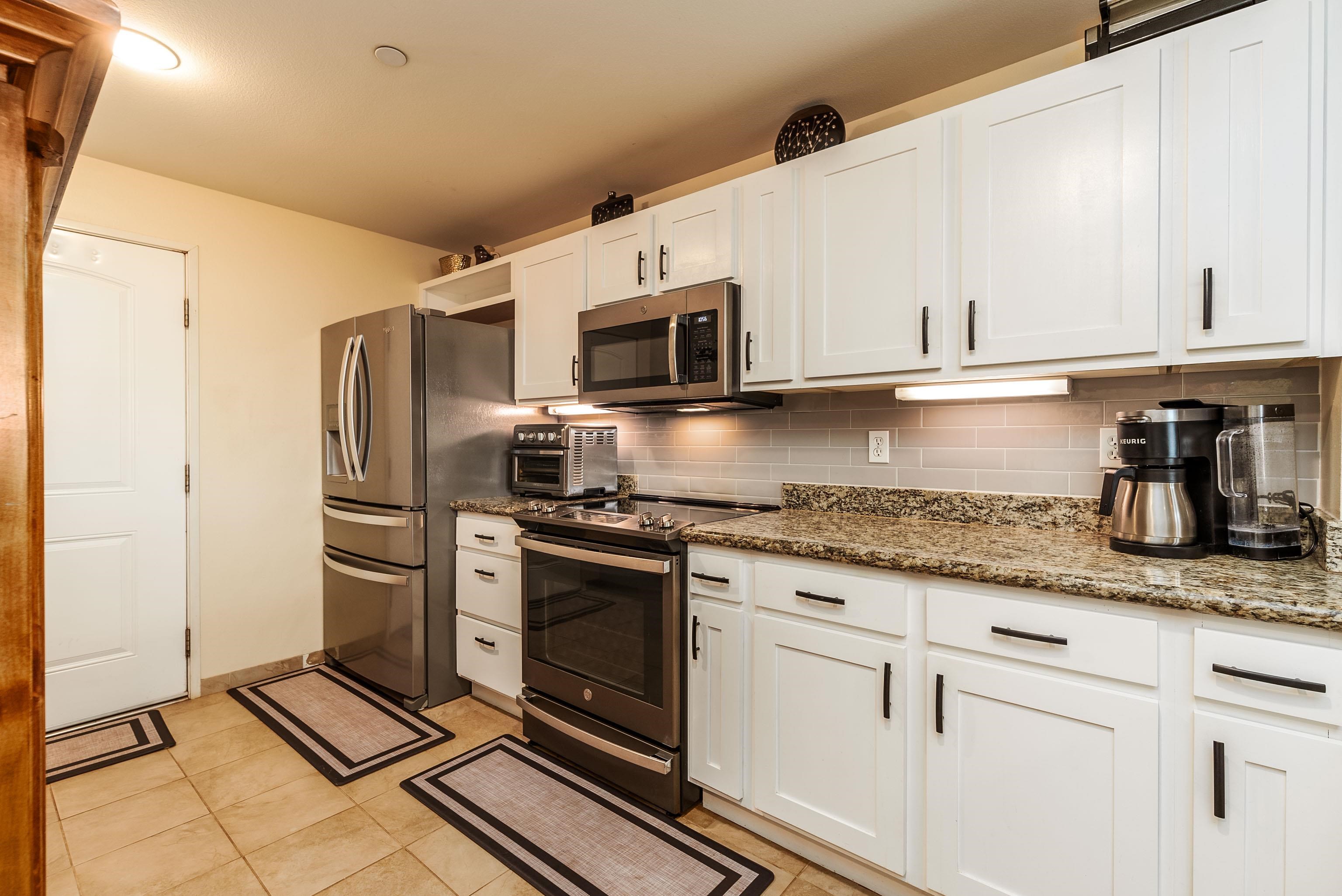 3708 Lower Honoapiilani Road, Unit E43 Lahaina, HI 96761 - Photo 6 of 40 a kitchen with granite countertop a sink stove and refrigerator