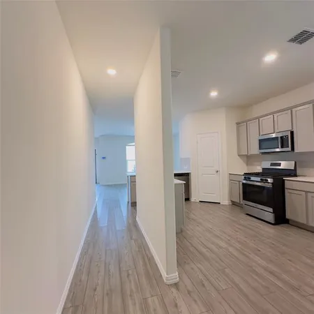 a view of a kitchen with wooden floor and electronic appliances