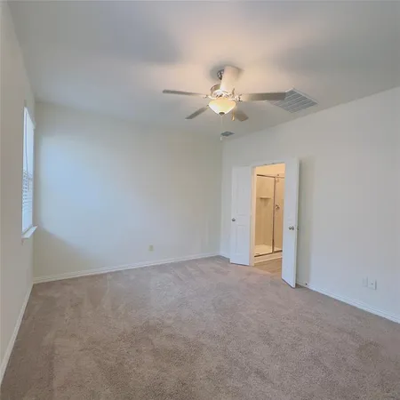 an empty room with a window and a ceiling fan