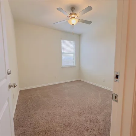 an empty room with a window and a fan