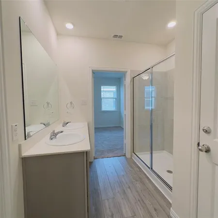 a bathroom with a sink mirror and shower