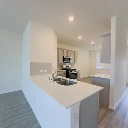 a kitchen with granite countertop a sink and a refrigerator