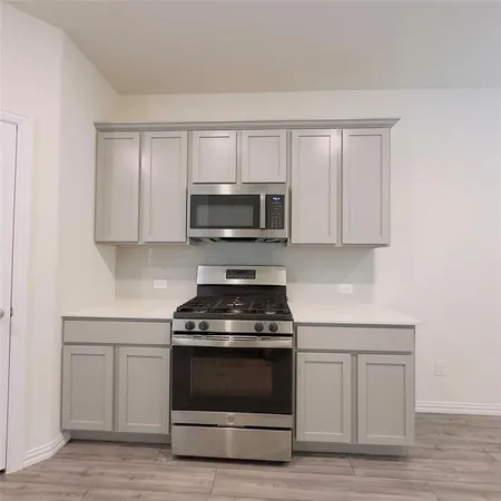 a kitchen with white cabinets and stainless steel appliances