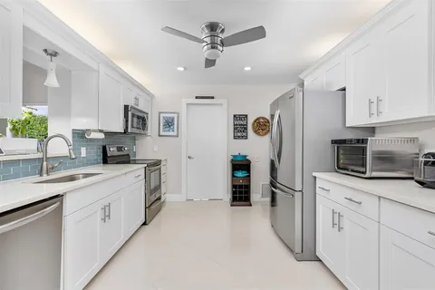 a kitchen with white cabinets and stainless steel appliances
