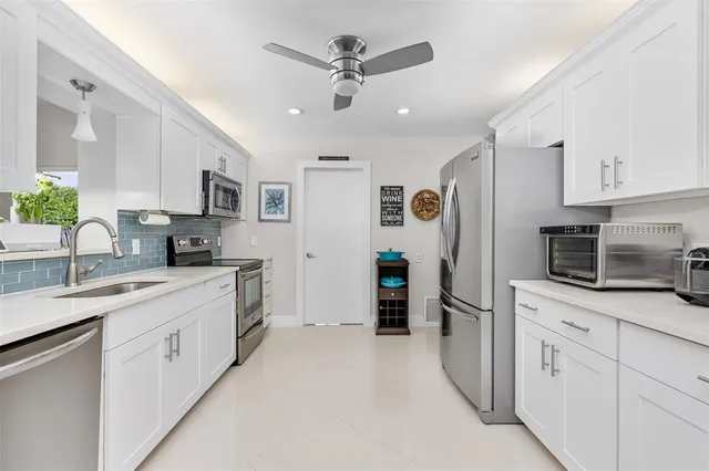 a kitchen with white cabinets and stainless steel appliances