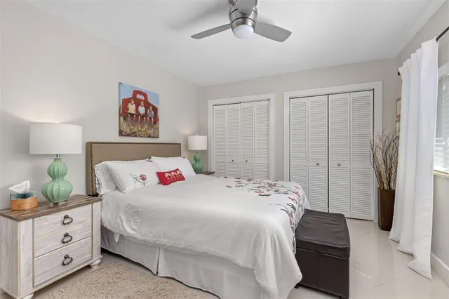 a bedroom with a bed and a potted plant on the dresser